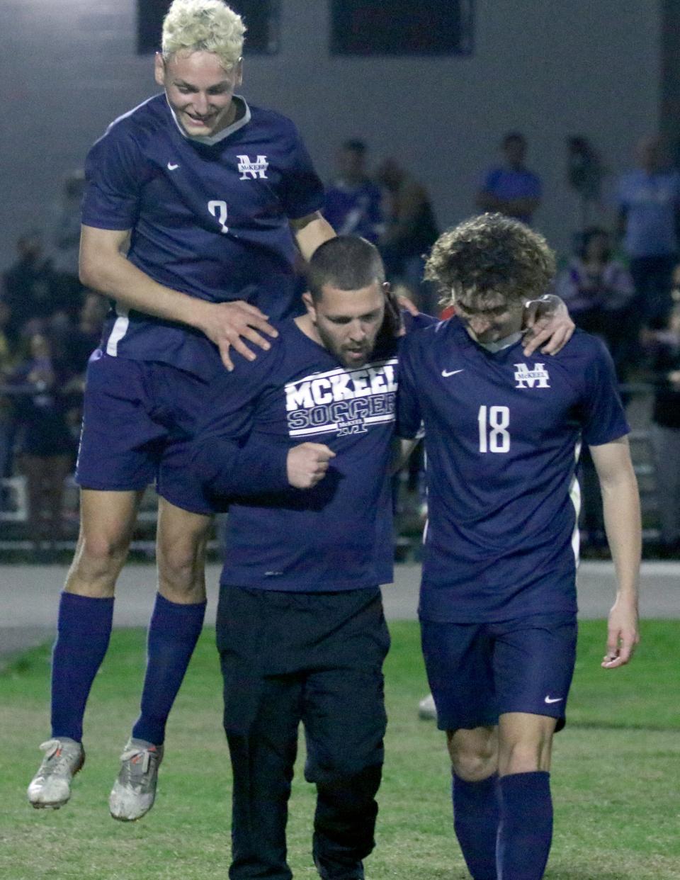 McKeel sophomore Drew Snyder celebrates with head coach Tanner Adams and junior Konnor Dobson after McKeel defeated Tampa King in the penalty kick shootout.