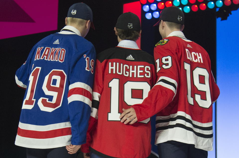 New York Rangers draft pick Kaapo Kakko, left; New Jersey Devils pick Jack Hughes, center; and Chicago Blackhawks pick Kirby Dach pose for photos during the first round of the NHL hockey draft Friday, June 21, 2019, in Vancouver, British Columbia. (Jonathan Hayward/The Canadian Press via AP)