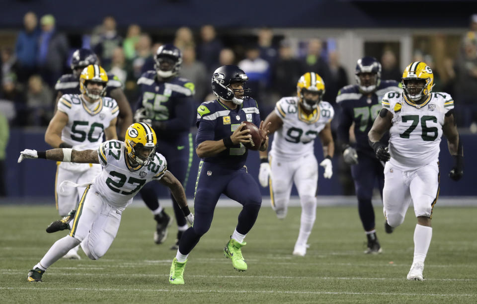 Seattle Seahawks quarterback Russell Wilson (3) scrambles away from Green Bay Packers defensive back Josh Jones (27) during the first half of an NFL football game Thursday, Nov. 15, 2018, in Seattle. (AP Photo/Stephen Brashear)