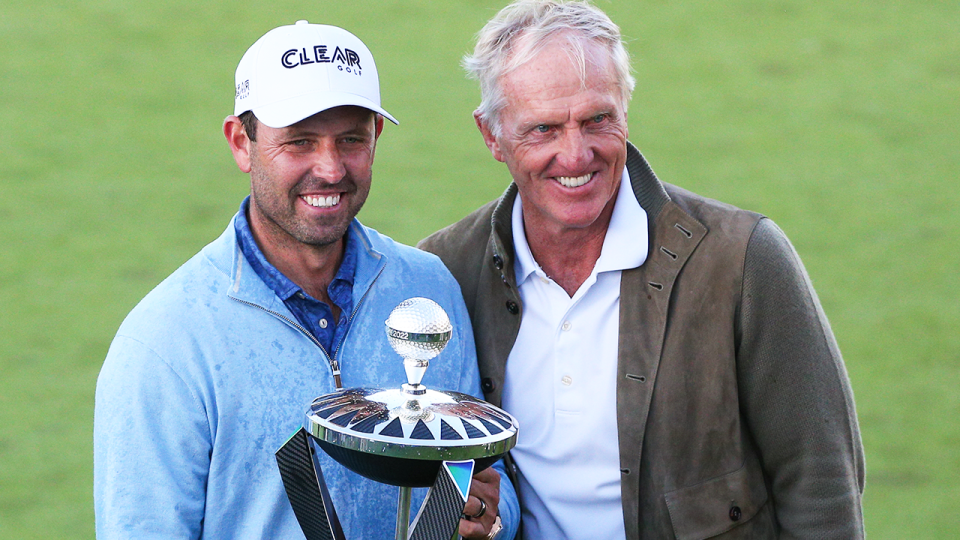 Charl Schwartzel (pictured left) holds the winners trophy and poses for a photo with Greg Norman (pictured right).