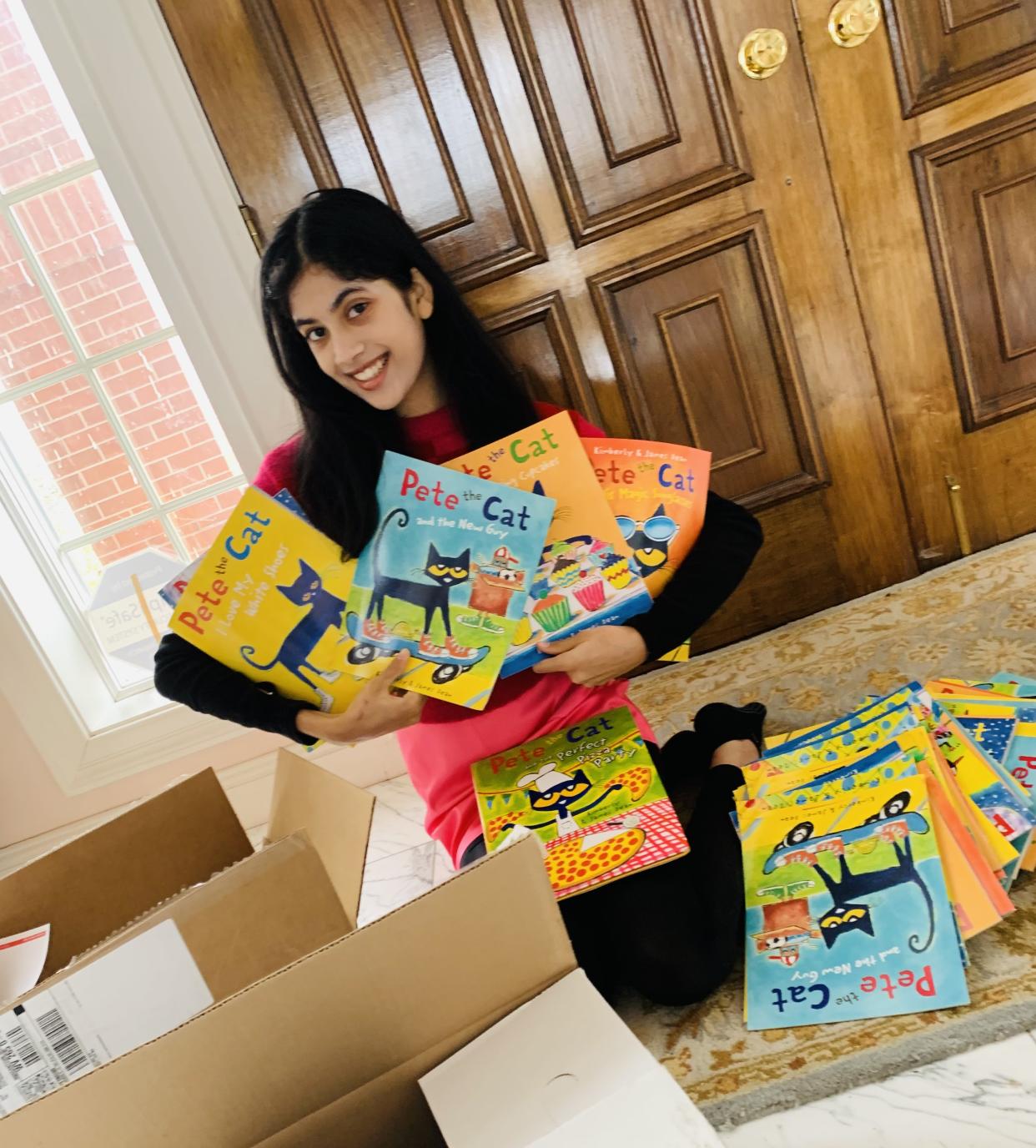 Zuri poses with books to be donated. (Rania Zuri)