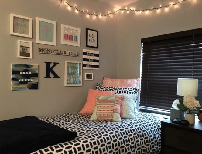 A gallery between a twin bed and fairy lights, including "Good Vibes" and "Holy Chic" framed posters