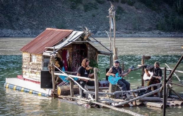 Dawson City musician Holly Haustein, who goes by the name Driftwood Holly as a musician, performs with his friends on his houseboat, The Wooden Pearl, on the Yukon River in Dawson City. (Photo submitted by Driftwood Holly. - image credit)