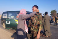 In this photo released by the Syrian official news agency SANA, a resident hugs a Syrian soldier shortly after Syrian troops entered the northern town of Tal Tamr, Monday, Oct 14, 2019. The move toward Tal Tamr came a day after Syria's Kurds said Syrian government forces agreed to help them fend off Turkey's invasion — a major shift in alliances that came after President Donald Trump ordered all U.S. troops withdrawn from the northern border area amid the rapidly deepening chaos. (SANA via AP)