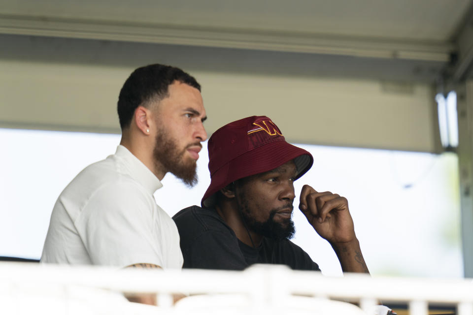 Phoenix Suns NBA basketball player Kevin Durant, right, watches a Washington Commanders NFL football practice at the team's training facility, Friday, July 28, 2023, in Ashburn, Va. (AP Photo/Stephanie Scarbrough)