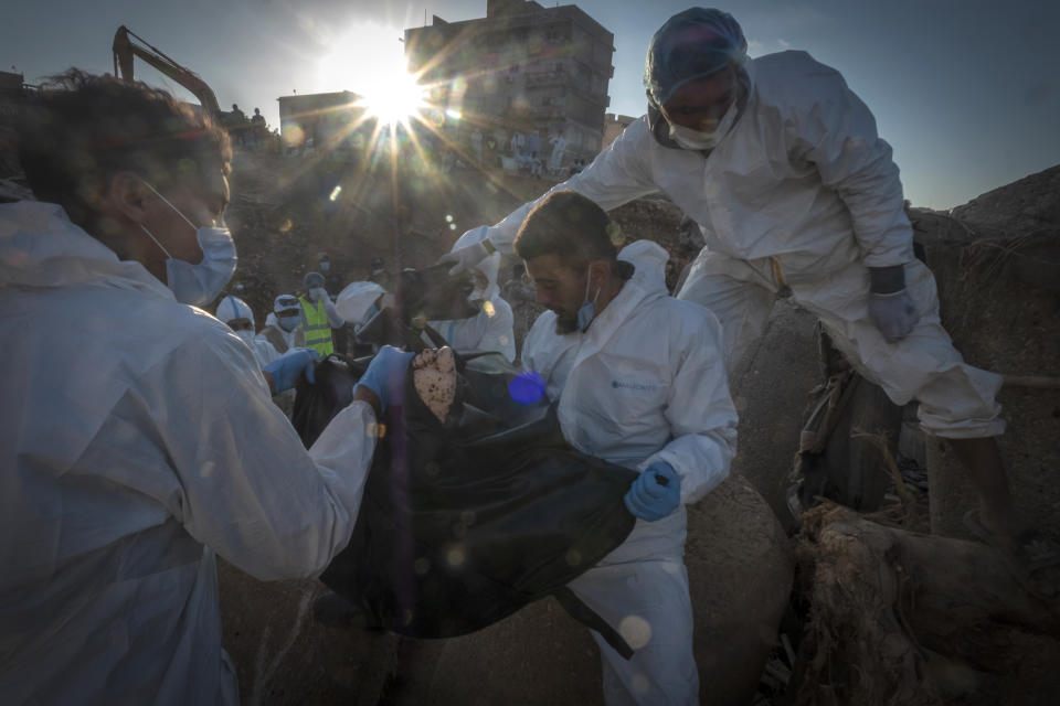 Rescuers recover the body of a victim killed during flooding in Derna, Libya, Friday, Sept. 15, 2023. Search teams are combing streets, wrecked buildings, and even the sea to look for bodies in Derna, where the collapse of two dams unleashed a massive flash flood that killed thousands of people. (AP Photo/Ricardo Garcia Vilanova)