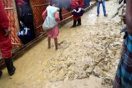 A child wades through mud after a storm at the Chakmarkul refugee camp, in Cox's Bazar, Bangladesh June 10, 2018. Picture taken June 10, 2018. Kristiana Marton/Save the Children/Handout via REUTERS