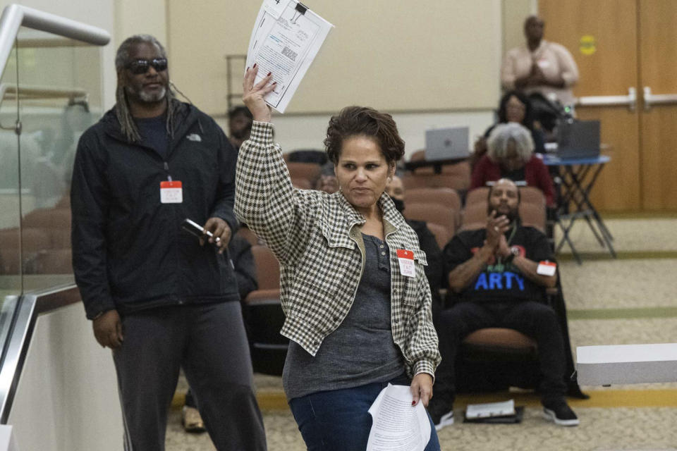 Dawn Basciano holds up legal documents while speaking during public commentS at the California Reparations Task Force meeting, Wednesday, March 29, 2023, in Sacramento, Calif. She said her ancestors had land in Coloma taken by the state parks system. The leader of the reparations task force said it won't take a stance on how much the state should compensate individual Black residents. (Hector Amezcua/The Sacramento Bee via AP)