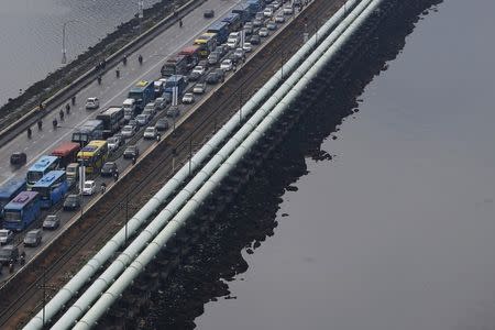 FILE PHOTO: Water pipes run the length of the causeway between Singapore and Malaysia's southern city of Johor Bahru (R), transporting up to 250 million gallons (946 million litres) of water or approximately 60 percent of Singapore's water needs each day, March 10, 2016. REUTERS/Edgar Su/File Photo