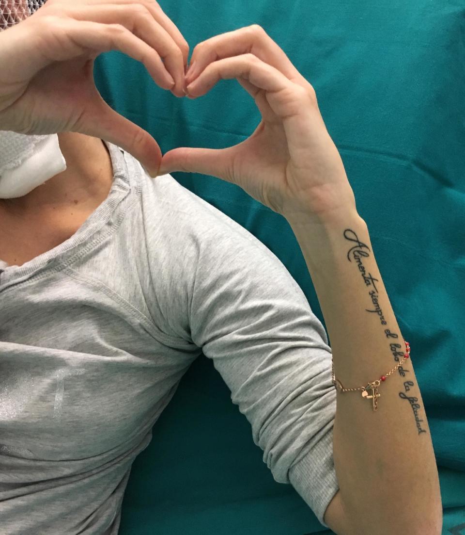 In this photo taken on Jan. 24, 2017, Gessica Notaro, victim of an acid attack, forms a heart with her fingertips from her bed of a hospital in Cesena, Italy. A rebellion against gender violence, slowly taking root in Italian society, marks a stunning turnabout. Barely a generation ago, the Italian penal code still prescribed prison sentences as short as three years for male defendants who killed “their” women out of jealousy; husbands alone were legally empowered to decide the important questions in their household. (Mauro Catalini via AP)