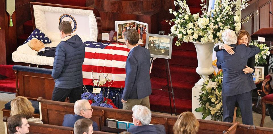 Julie Pagano, fiancée of former Congressman William Delahunt, hugs a mourner during a wake for the Quincy Democrat at the historic United First Parish Church - "Church of Presidents" - in Quincy Square on Friday, April 5, 2024.