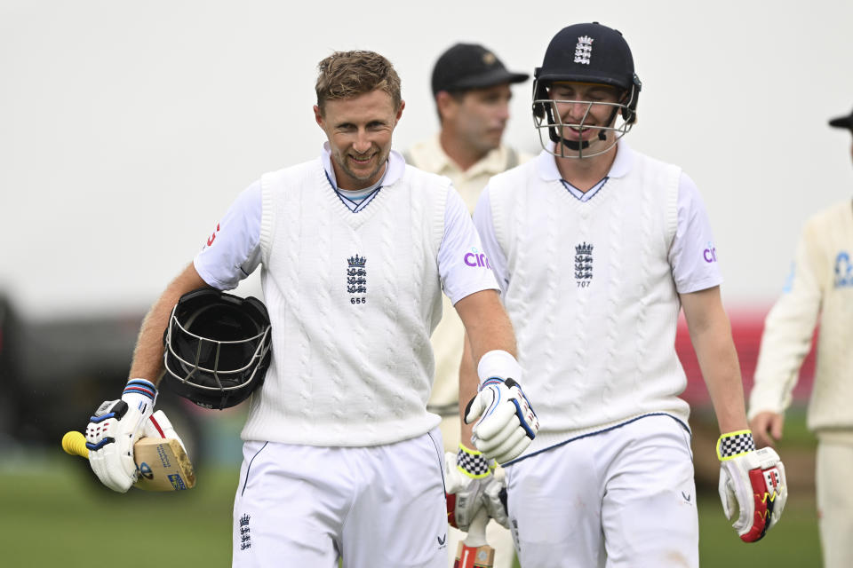 England's Joe Root, left, and teammate Harry Brook walk the field during as rain stops play on the first day of the second cricket test against New Zealand at the Basin Reserve in Wellington, New Zealand, Friday, Feb. 24, 2023. (Andrew Cornaga/Photosport via AP)