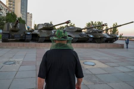 A man wears a mosquito head net as he walks past World War II era tanks in the banks of Volga river in Volgograd, Russia, June 21, 2018. REUTERS/Sergio Perez