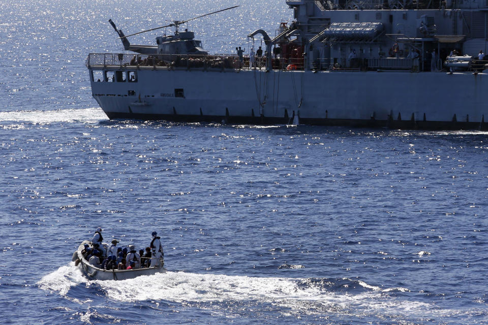 FILE - Migrants are transferd by Italian sailors from the German combat supply ship 'Frankfurt am Main' to the their ship 'Grecale' after being rescued during EUNAVFOR MED Operation Sophia in the Mediterranean Sea off the coast of Libya on March 29, 2016. A confidential European Union military report calls for the continued support and training of Libya’s coastguard and navy despite concerns about their treatment of migrants, a mounting death toll at sea, and the continued lack of any central authority in the North African nation. The report circulated to EU officials on Jan. 4 and obtained by The Associated Press offers a rare insight into Europe’s determination to cooperate with Libya and its role in the interception and return of thousands of men, women and children to a country where they face insufferable abuse. (AP Photo/Matthias Schrader, File)