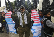 <p>A protestor holds torn representations of American and Israeli flags during a protest at the Unknown Soldier Square in Gaza City, Wednesday, Dec. 6, 2017. (Photo: Adel Hana/AP) </p>