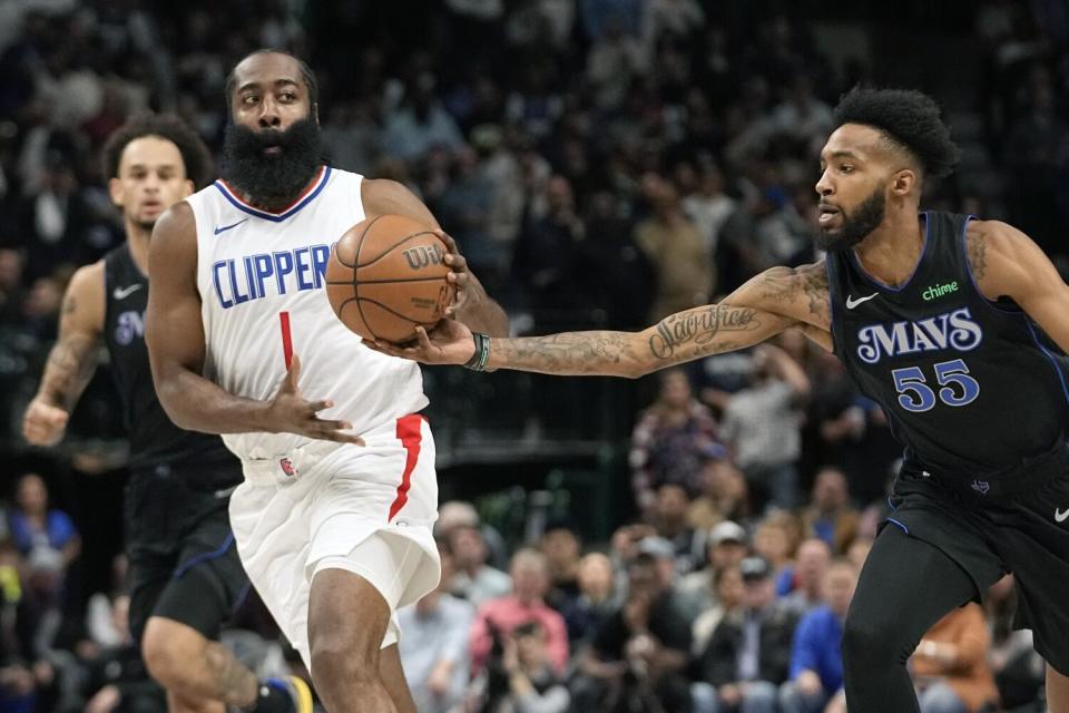 Clippers guard James Harden, left, tries to drive past Dallas Mavericks forward Derrick Jones Jr..