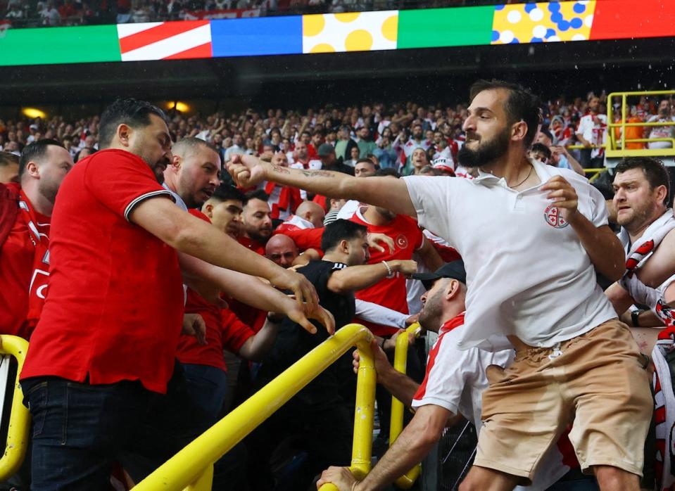 A Georgia fan launches a punche towards a rival supporting Turkey (Reuters)