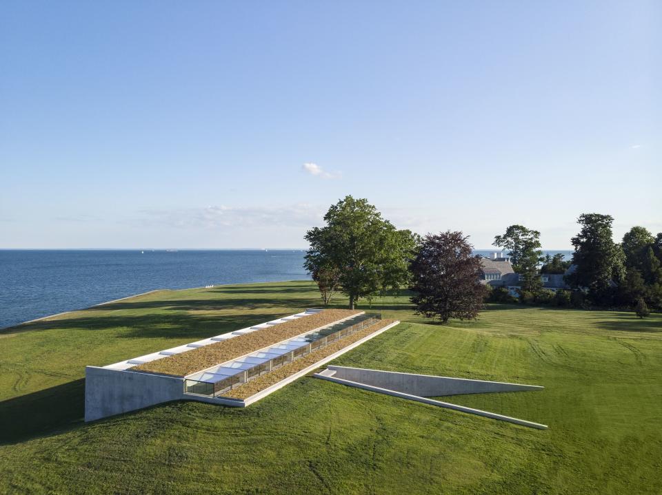 A minimalist pool house in Westport, Connecticut, designed by Rogers Ferris + Partners, was partially set into the earth, reducing the energy load. The green roof helps absorb excess heat and the south-facing glass wall passively warms the building.