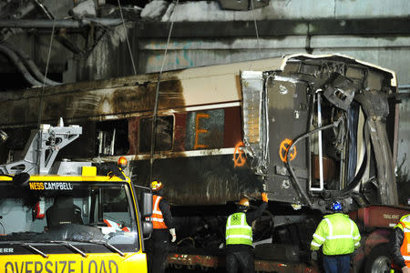 A damaged Amtrak passenger train car is lifted from the tracks at the site of the derailment of Amtrak train 501 in Dupont, Washington, U.S., December 19, 2017. REUTERS/Thomas James