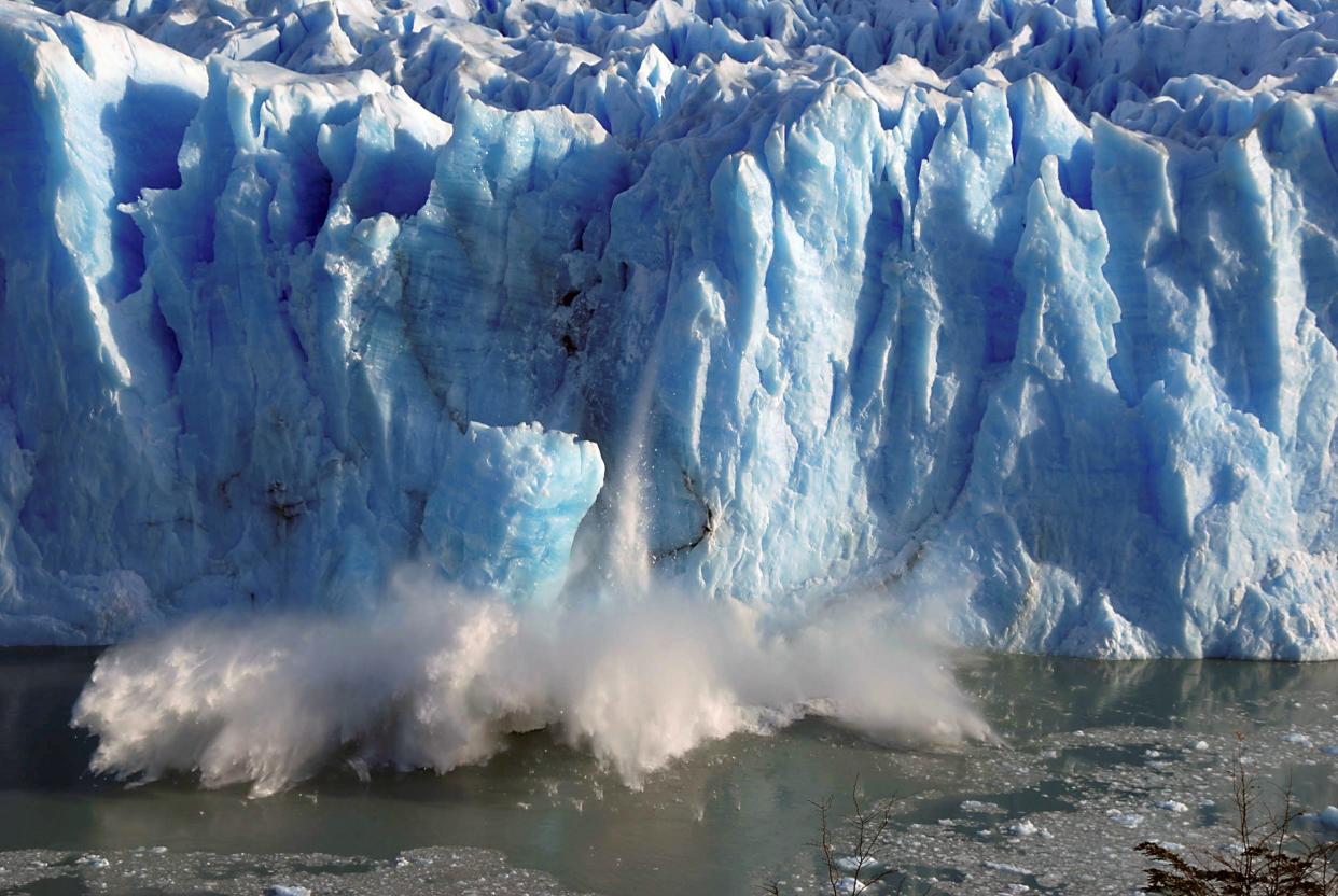 glacier calving splinters of ice fall into ocean