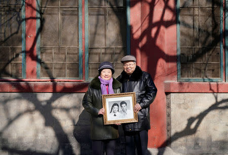 Huang Fusheng (R), 83, and his wife Tang Lanfang, 80, pose with their wedding photo taken in 1958, at Prince Fu Mansion built during Qing dynasty, where they worked together from 1965 to 1992, in central Beijing, China, February 7, 2018. Introduced to one another by their supervisor in 1956, the couple worked together at the mansion, which housed an office under the China National Publications Import and Export Corporation, for 27 years. "I think our marriage is still fresh because we believed in forgiving and understanding each other," said Lanfang. REUTERS/Jason Lee