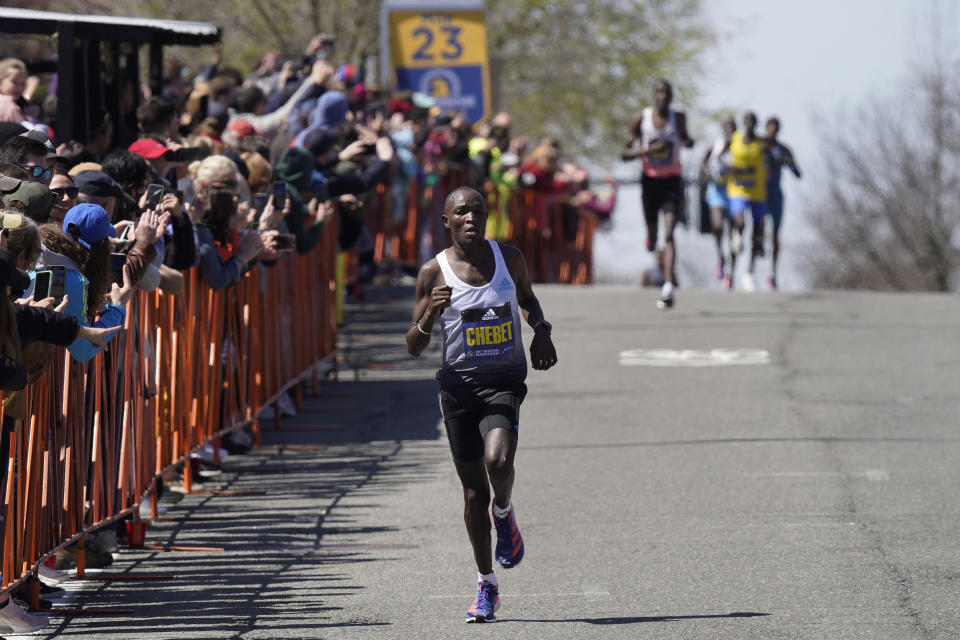 Evans Chebet, of Kenya, front, runs ahead of other elite runners in Brookline, Mass., on his way to win the men's division of the Boston Marathon, Monday, April 18, 2022. (AP Photo/Steven Senne)