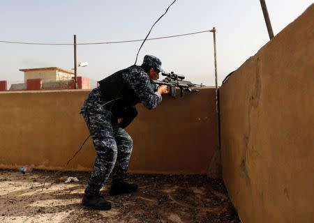 A member of Federal police looks at the positions of Islamic State militants during clashes in western Mosul, Iraq, May 15, 2017. REUTERS/Danish Siddiqui