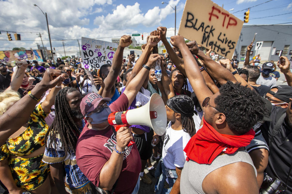 Protesters raise their fists as Bishop Freddie Marshall of Christ Cathedral of the Triad speaks using a bullhorn in Greensboro, North Carolina, on May 30. (Photo: Woody Marshall/News & Record via Associated Press)