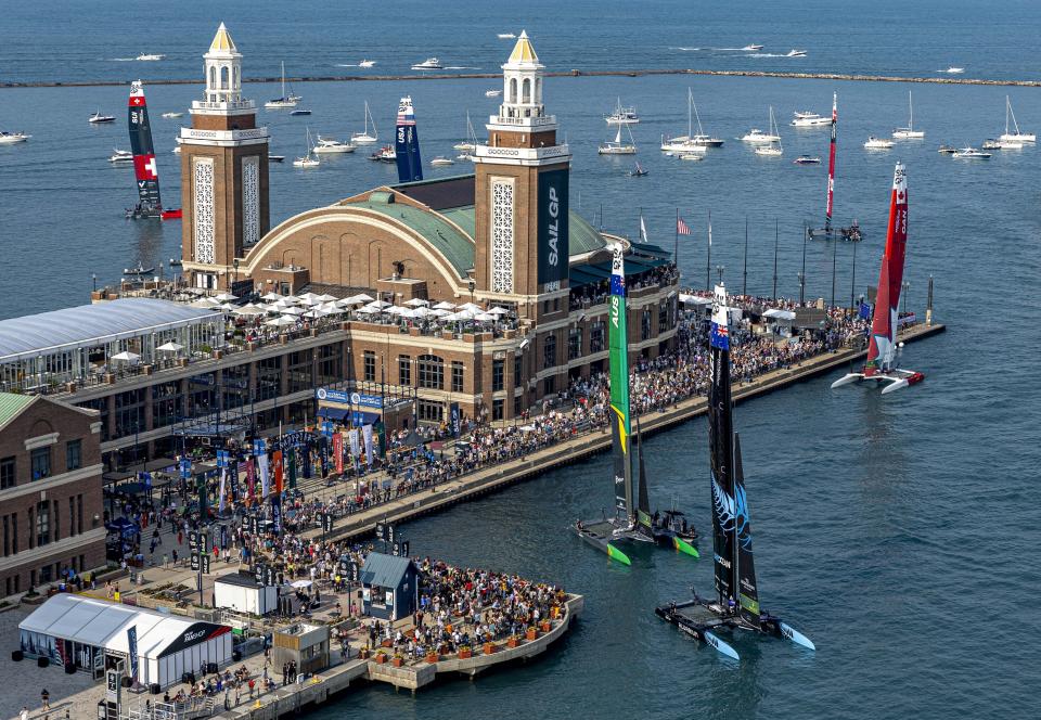 In this photo provided by SailGP, the New Zealand SailGP Team, bottom right, the Australia SailGP Team, left, and the Canada SailGP Team, right, sail close to spectators in the SailGP Race Stadium on Navy Pier after the New Zealand SailGP Team, helmed by Peter Burling, won the United States Sail Grand Prix | Chicago, Season 4, in Chicago, Saturday, June 17, 2023. (Simon Bruty/SailGP via AP)