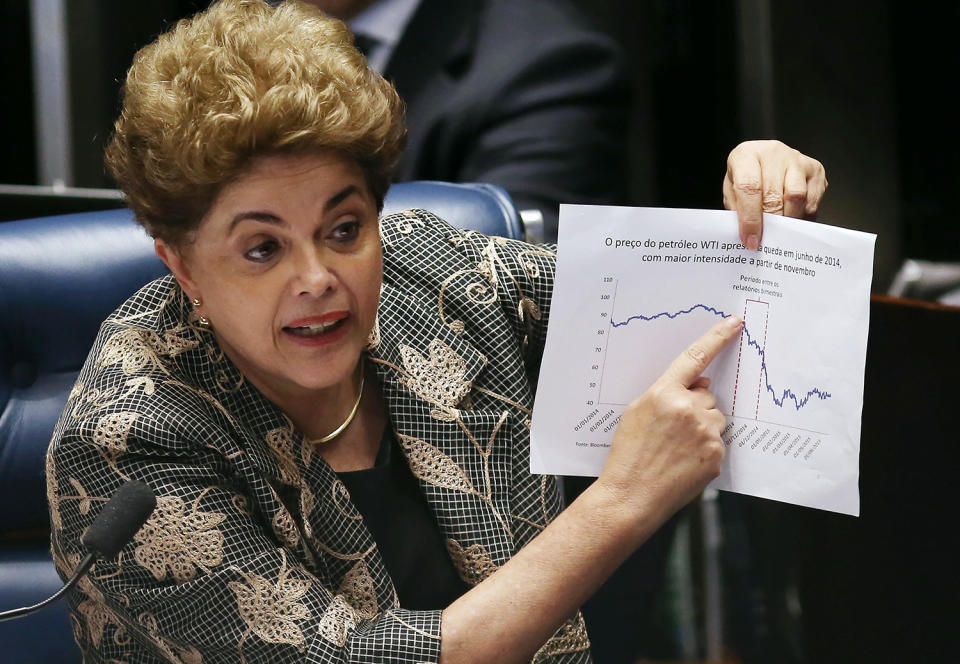 <p>Suspended President Dilma Rousseff points to an economic chart displaying oil prices during her impeachment trial, Aug. 29, 2016, in Brasilia. (Photo: Mario Tama/Getty Images) </p>