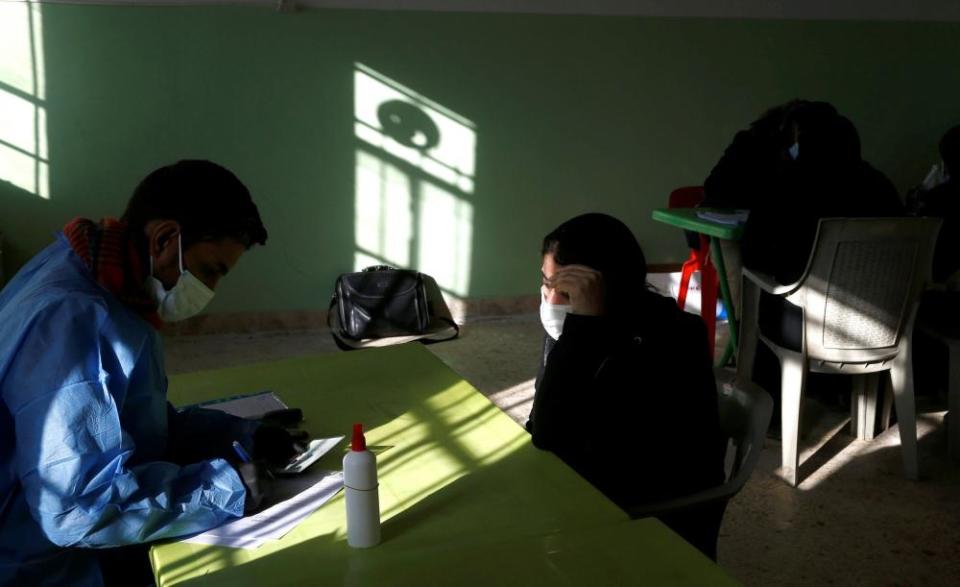 An employee from the Martyrs’ Foundation fills out a missing persons form for a Yazidi woman looking for a relative missing after the August 2014 Isis attack in Kocho.