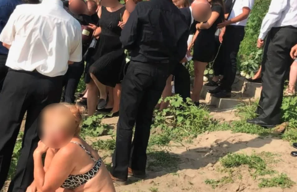 A woman snapped sunbathing at a funeral has divided internet users. Photo: Reddit/Gombi20