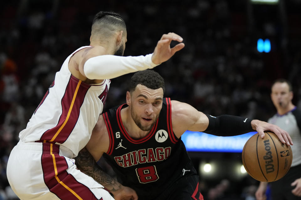 Chicago Bulls guard Zach LaVine (8) drives past Miami Heat forward Caleb Martin, left, during the second half of an NBA basketball play-in tournament game, Friday, April 14, 2023, in Miami. (AP Photo/Rebecca Blackwell)