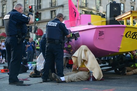 Police work to remove protesters from a boat being used to block traffic at an intersection near the White House in Washington