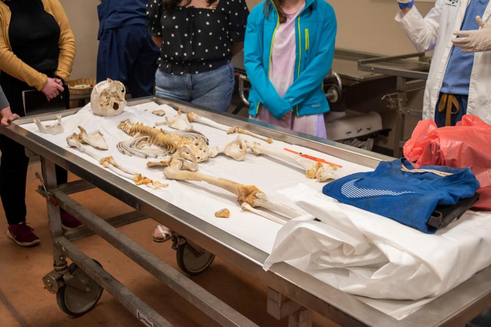 Students observe a migrant skeleton at the Medical Examiner’s office in Arizona as a forensic anthropologist explains how they identify remains.