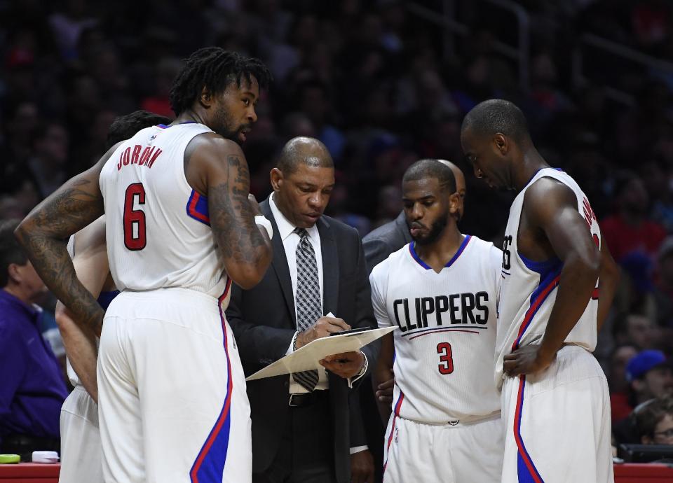 Los Angeles Clippers head coach Doc Rivers, second from left, talks with center DeAndre Jordan, left, guard Chris Paul, second from right, and forward Luc Mbah a Moute, of Cameroon, during the second half of an NBA basketball game against the Charlotte Hornets, Sunday, Feb. 26, 2017, in Los Angeles. The Clippers won 124-121 in overtime. (AP Photo/Mark J. Terrill)