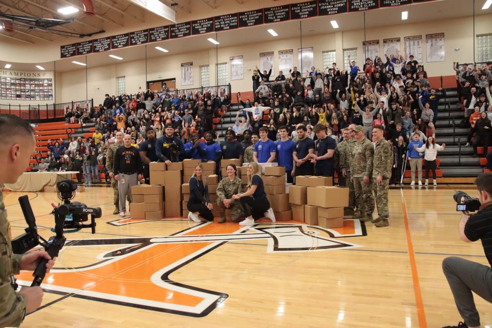 Tecumseh High School students, University of Michigan student-athletes and Michigan Army National Guard members pose for photos and video during an assembly Friday at Tecumseh High School with the Michigan Army National Guard and University of Michigan student-athletes.