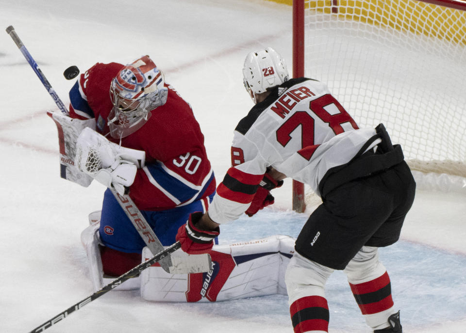 Montreal Canadiens goaltender Cayden Primeau (30) makes a save as New Jersey Devils' Timo Meier (28) watches during the first period of an NHL hockey game Tuesday, Oct. 24. 2023, in Montreal. (Christinne Muschi/The Canadian Press via AP)