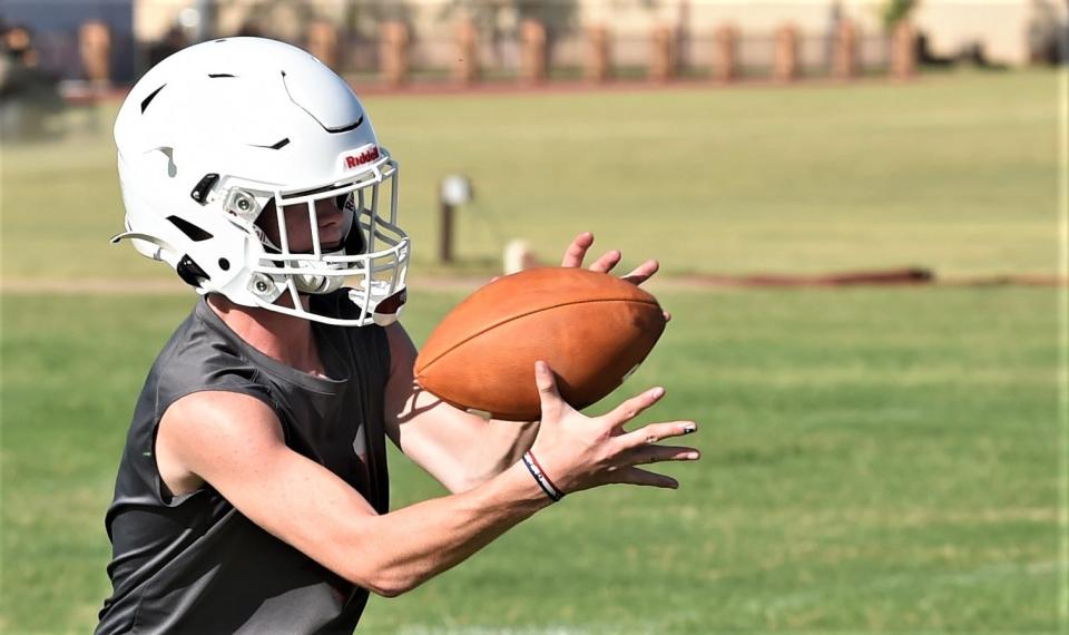 A Hawley player catches a pass during a drill on the first day of fall practice Monday at Hawley High School.