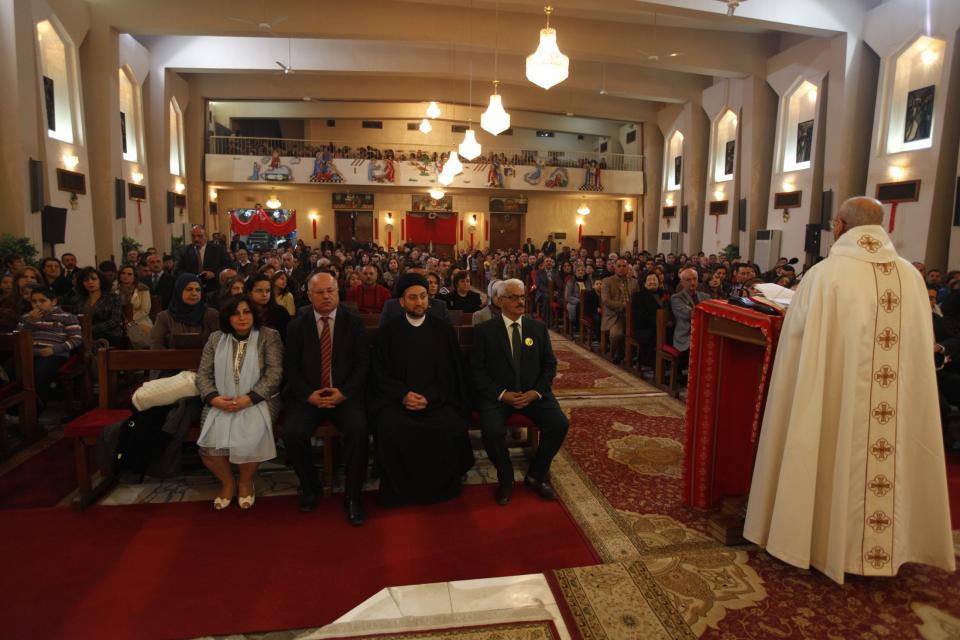 Ammar al-Hakim, leader of the Supreme Islamic Iraqi Council (front row, 2nd R), attends a Christmas Eve Mass at St. Joseph Chaldean Church in Baghdad, December 24, 2013. REUTERS/Ahmed Saad (IRAQ - Tags: RELIGION POLITICS)
