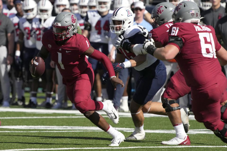 Washington State quarterback Cameron Ward (1) runs away from pressure in the first half during an NCAA college football game against Arizona, Saturday, Nov. 19, 2022, in Tucson, Ariz. (AP Photo/Rick Scuteri)