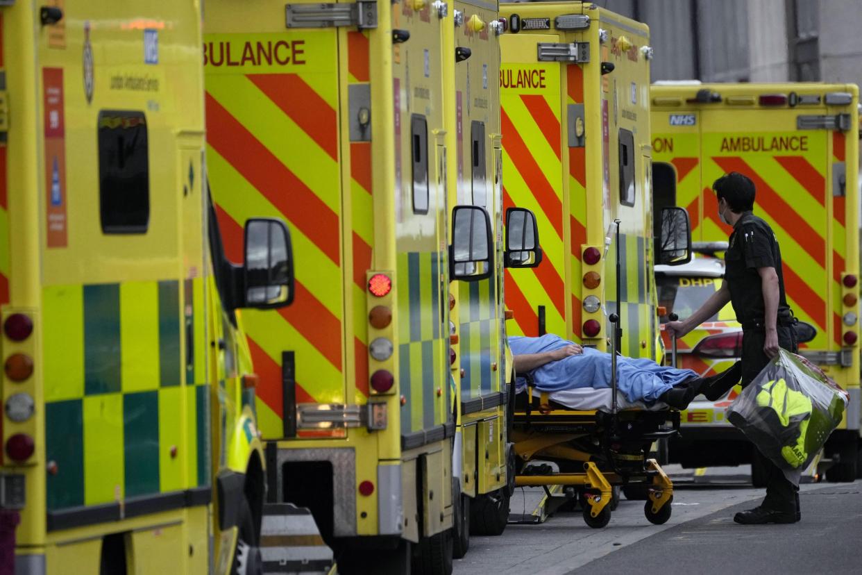 A patient is pushed on a trolley after arriving in an ambulance outside the Royal London Hospital. (AP)