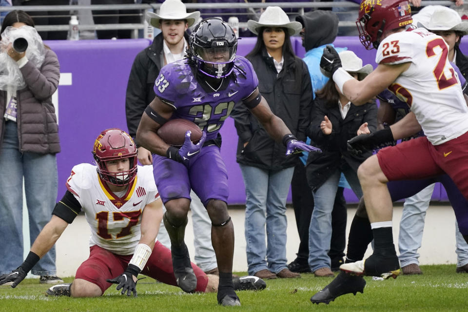 TCU running back Kendre Miller beats Iowa State defenders Beau Freyler (17) and Will McLaughlin on his way to score a touchdown during the first half of an NCAA college football game in Fort Worth, Texas, Saturday, Nov. 26, 2022. (AP Photo/LM Otero)