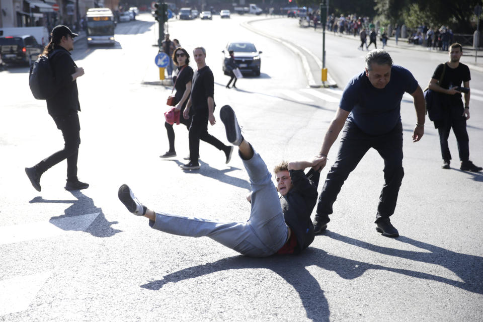 Police remove protesters of Last Generation who were blocking traffic in front of Colosseum in downtown Rome, to protest against the environment crisis Friday, Nov. 11, 2022. (Cecilia Fabiano/LaPresse via AP)