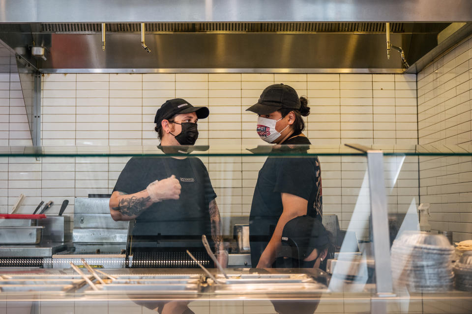 HOUSTON, TEXAS - JUNE 09: Employees speak together at a Chipotle Mexican Grill on June 09, 2021 in Houston, Texas. Menu prices at the Chipotle Mexican Grill have risen by roughly 4% to cover the costs of raising its&#39; minimum wage to $15 an hour for employees. The restaurant industry has been boosting wages in the hopes of attracting workers during a labor crunch. (Photo by Brandon Bell/Getty Images)