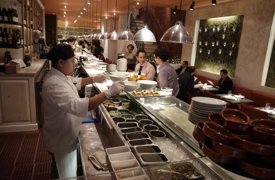 This Dec. 5, 2013 photo shows patrons at the Fig & Olive restaurant, in New York's Rockefeller Center. Rockefeller Center is crowded at Christmastime thanks to the famous tree, the skating rink and the show at Radio City Music Hall, but visitors can choose from a variety of places to eat in the area, from ethnic food and street carts to sit-down dining. (AP Photo/Richard Drew)