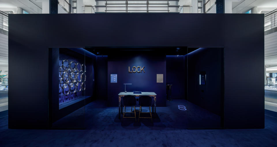Tiffany & Co. 'Lock' pop-up features an all sapphire blue shop-in-shop with a table and the words 'Lock' on the wall.