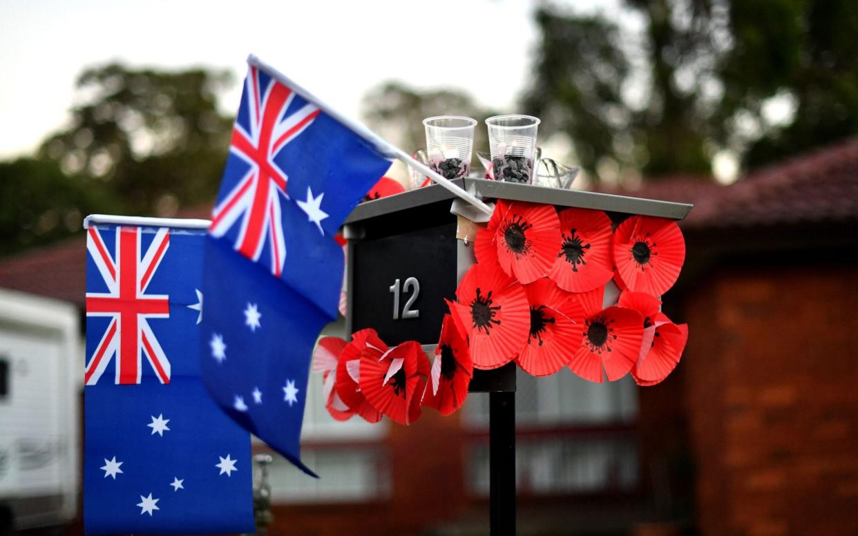 A mailbox is decorated with Australia's national flags and poppies flowers during the Anzac Day - Saeed Khan/AFP