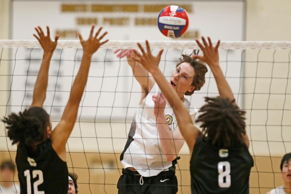 North Kingstown's Connor Valois blasts through a double block during the second set of Wednesday's match against Cranston East.