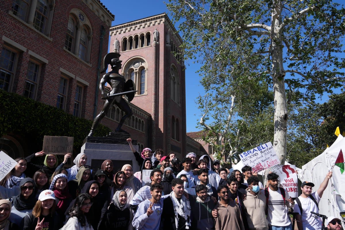 Pro-Palestinian students pose for photos in front of the Tommy Trojan statue on the campus of the University of Southern California (Copyright 2024 The Associated Press. All rights reserved.)